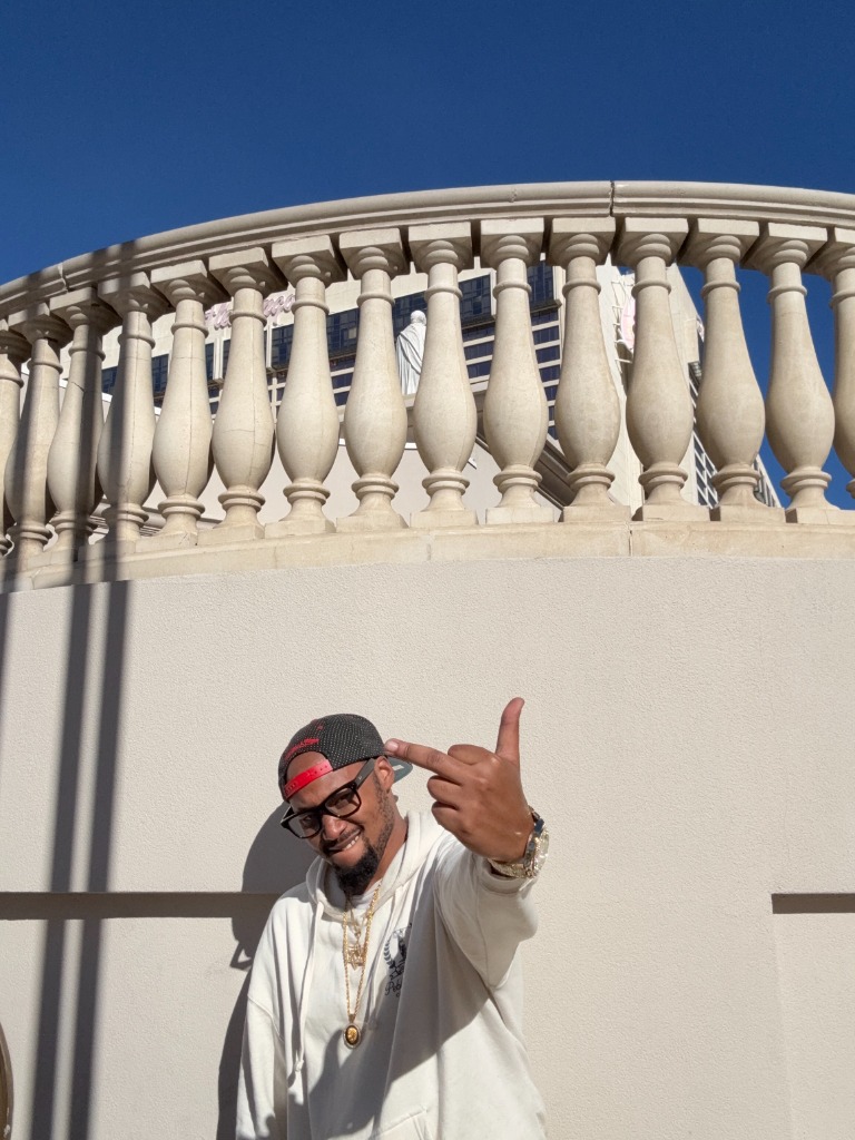 T Swerve standing in front of wall with red cap and glasses